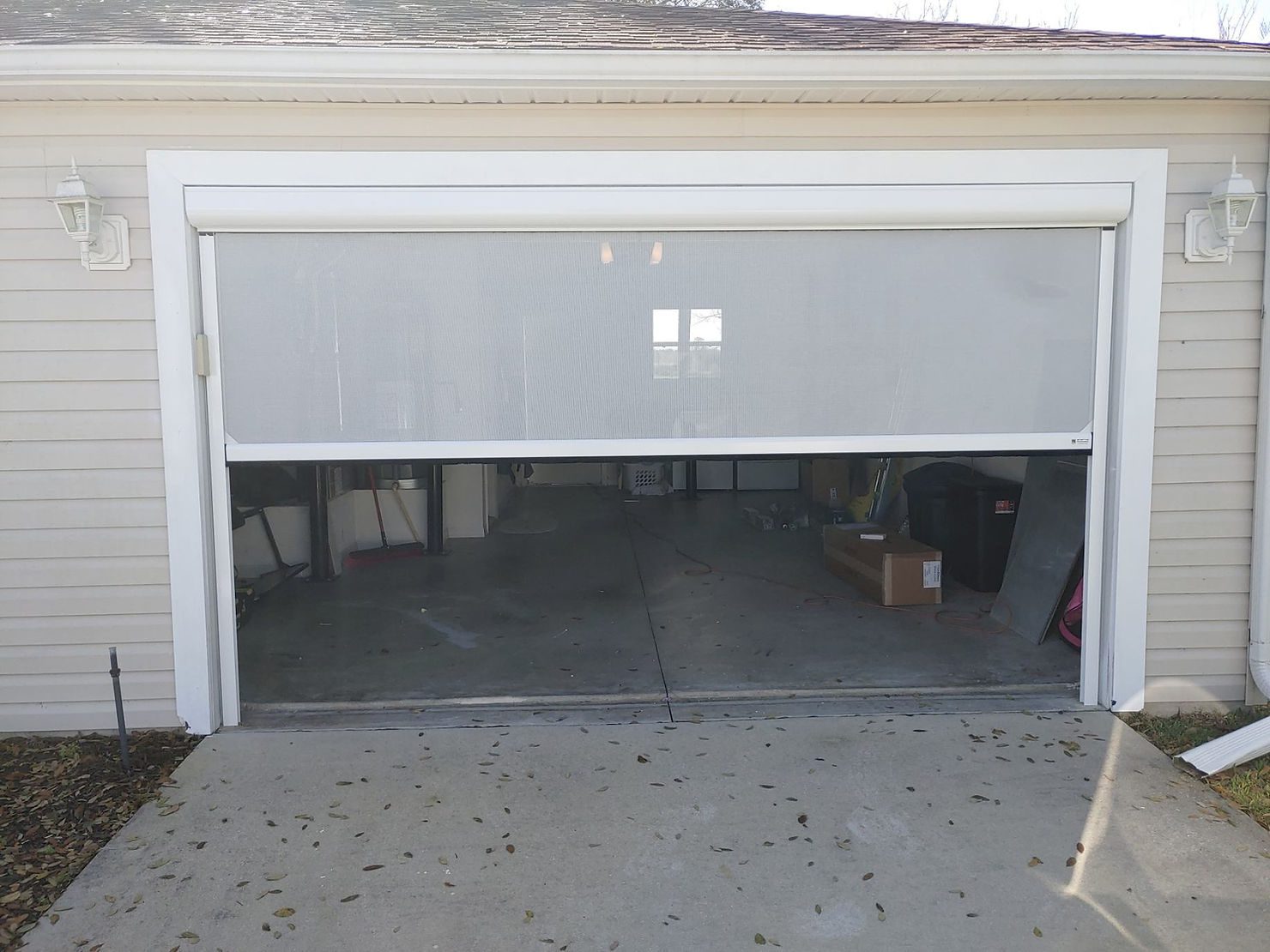 Partially open residential garage door with driveway