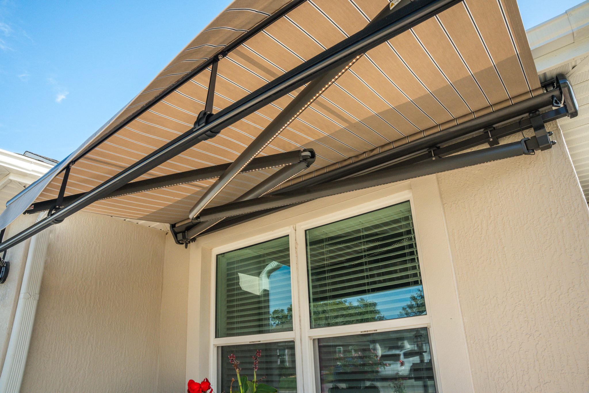 Retractable beige awning over residential window