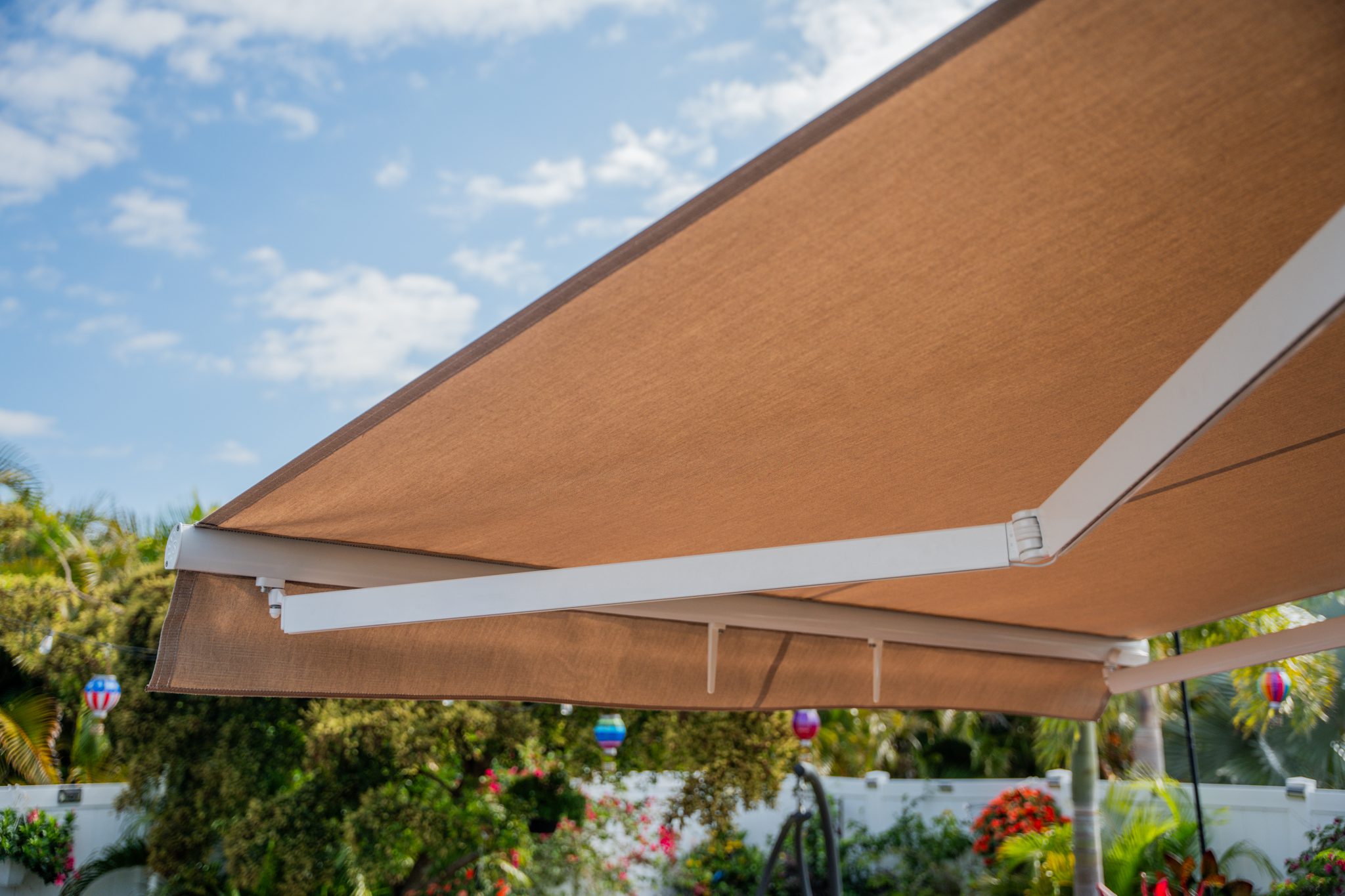 Retractable tan patio awning over garden