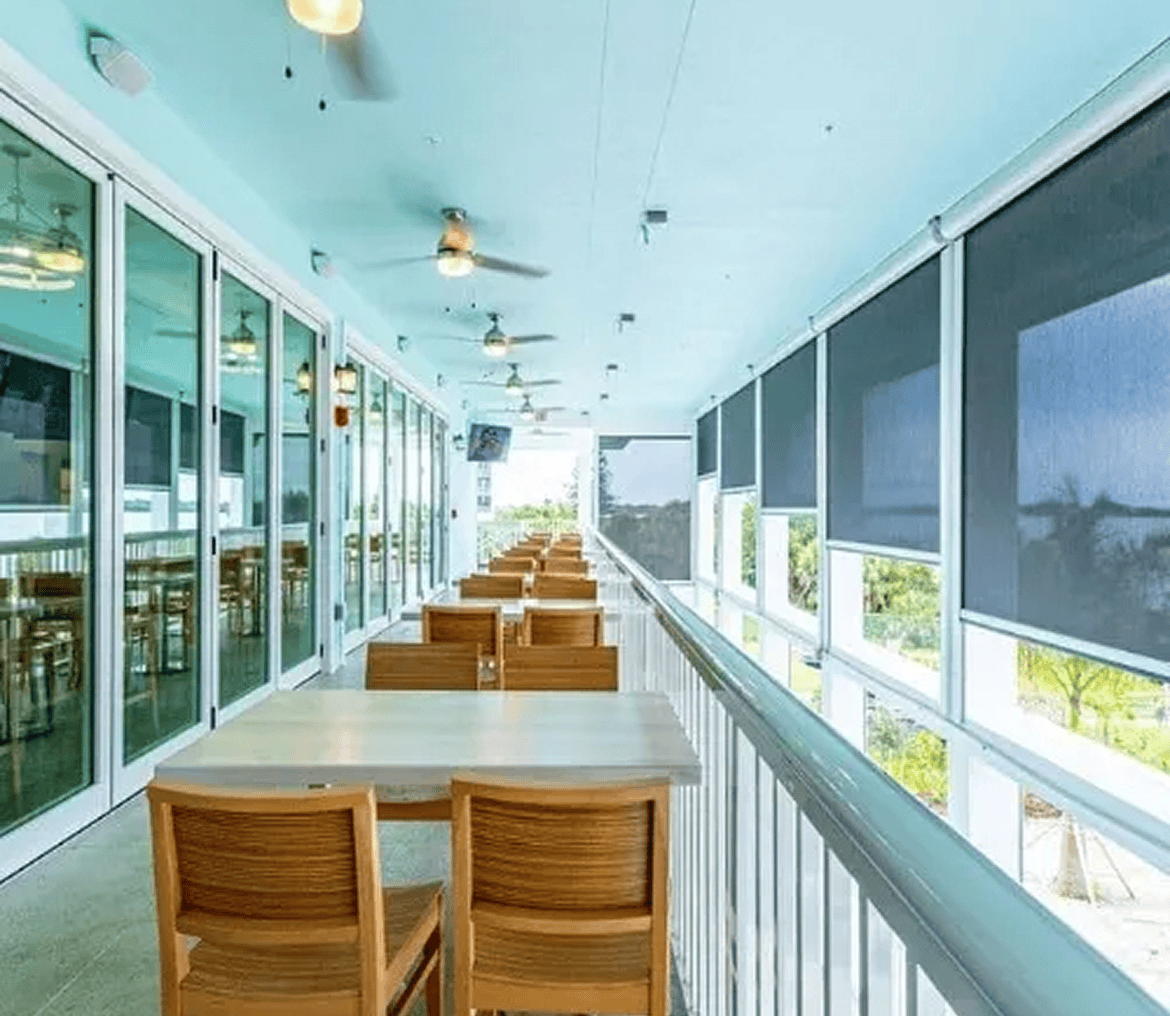 Covered balcony outdoor dining with wooden chairs