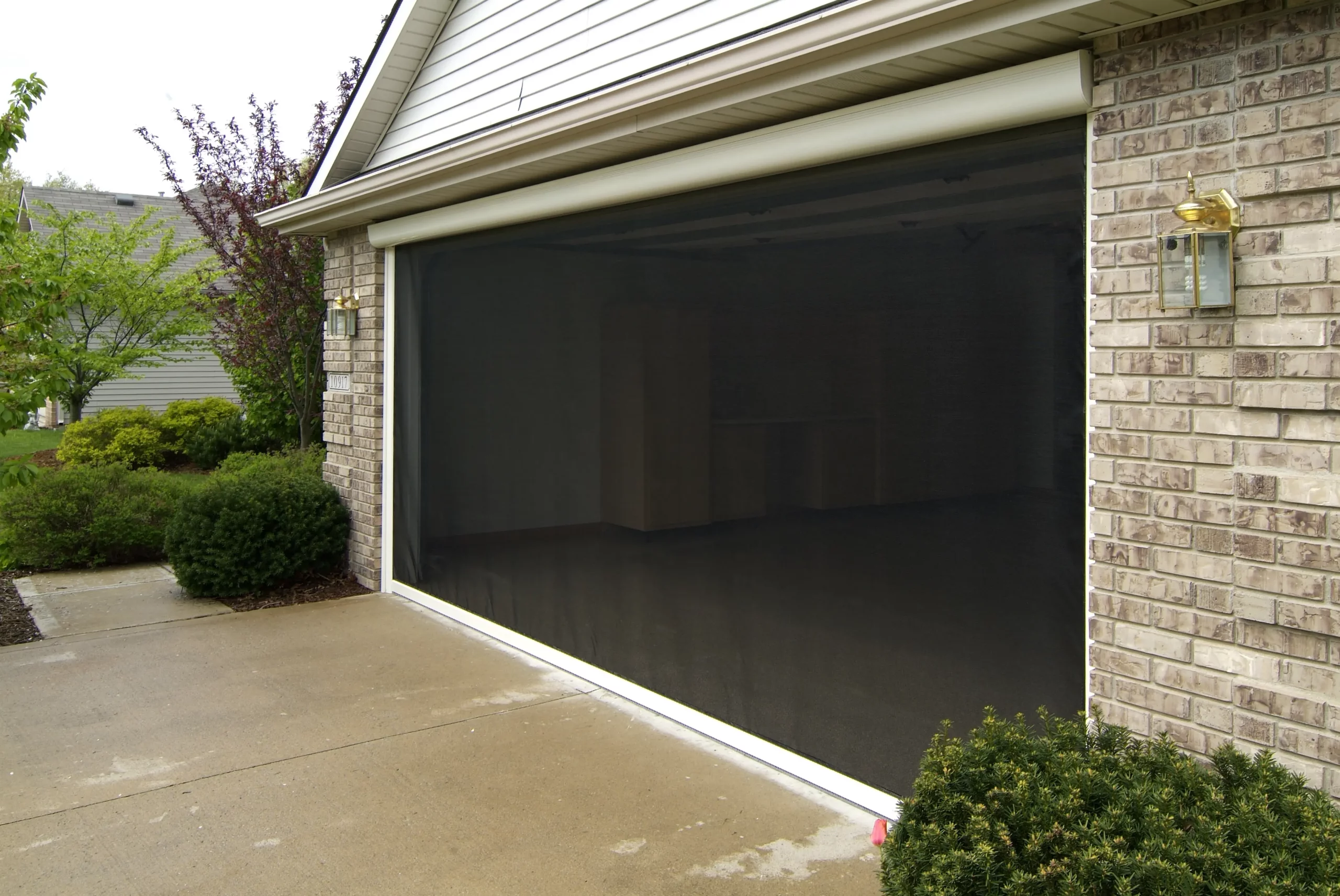 Brick house garage covered by retractable mesh screen